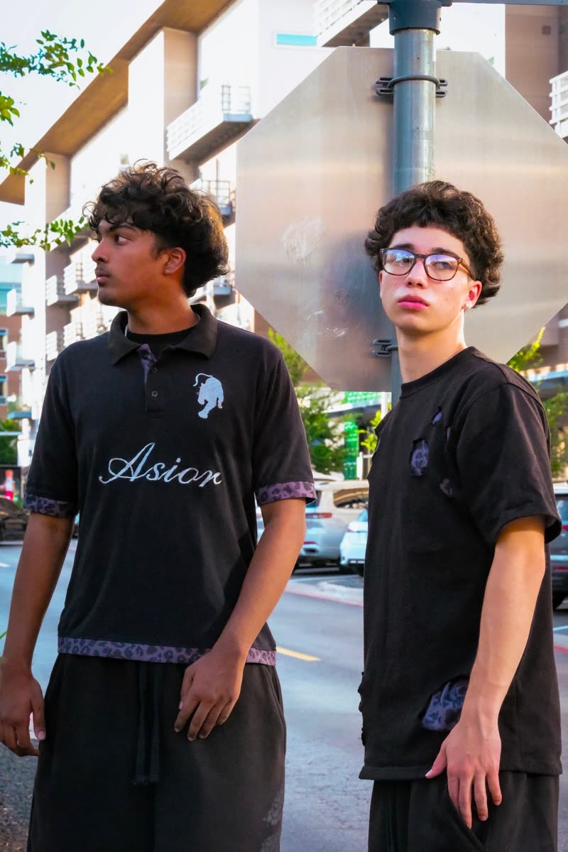 Two models on a street corner, one in the Asior Polo and one in the Holes Tee