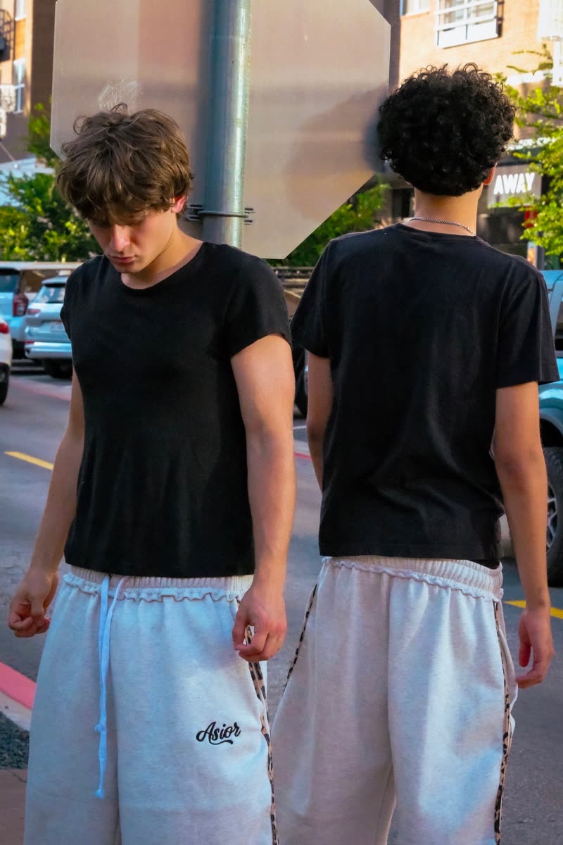 Two models from behind in black tees and light shorts